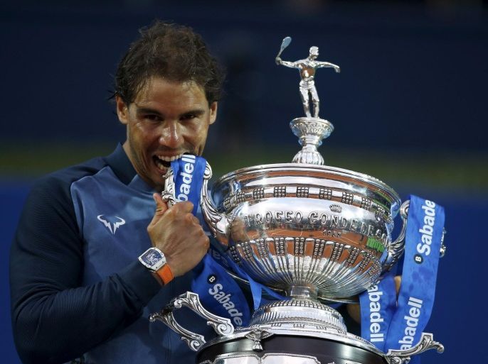 Rafael Nadal of Spain bites the Barcelona Open trophy after defeating Kei Nishikori of Japan in Barcelona, Spain, April 24, 2016. REUTERS/Albert Gea TPX IMAGES OF THE DAY