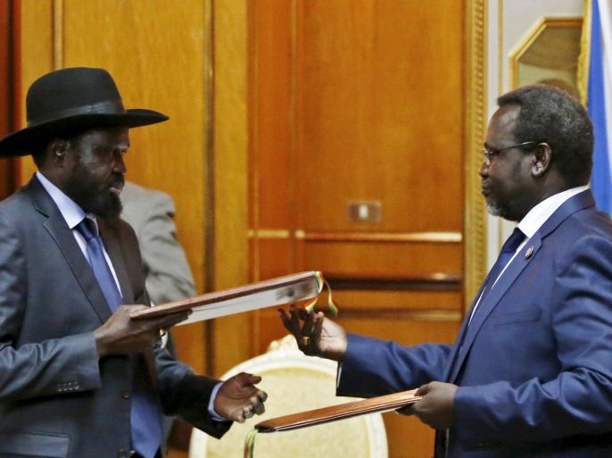 South Sudan's rebel leader Riek Machar (R) and South Sudan's President Salva Kiir exchange signed peace agreement documents in Addis Ababa in this May 9, 2014 file photo. REUTERS/Goran Tomasevic/Files