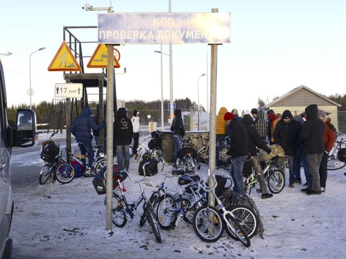 Refugees and migrants gather near a check point on the Russian-Norwegian border outside Nickel (Nikel) settlement in Murmansk region, Russia, October 30, 2015. The flow of Middle Eastern migrants trying to reach Europe via the Russian Arctic slowed dramatically on October 29, partly due to a shortage of bicycles to cross the border, a source who deals with them told Reuters. According to officials, many Syrians obtain business or study visas to enter Russia and then travel through Moscow and Murmansk to Nickel, a town of some 12,000 population named after the metal mined there. REUTERS/Fyodor Porokhin