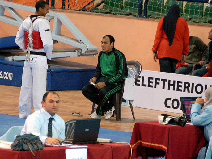 صورة للمدرب السعدني (بالملابس الخضراء) يشرف على مشاركة أحد اللاعبين في إحدى المسابقات (الجزيرة)