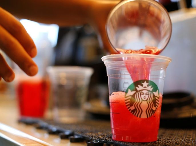 A barista pours a drink at a newly designed Starbucks coffee shop in Fountain Valley, California August 22, 2013. A Chicago woman has sued Starbucks Corp in federal court, claiming the world's largest coffee chain puts too much ice in chilled drinks, and is seeking $5 million. REUTERS/Mike Blake/File Photo