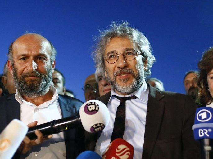 Can Dundar (C) and Erdem Gul (L), editors of the Cumhuriyet newspaper, speaks to media after the court announced that Can Dundar and Erdem Gul were sentenced to five years in prison for 'leaking state state secrets'. Journalists Can Dundar and Erdem Gul from the government-critical Cumhuriyet newspaper were arrested in November 2015 and held for three months after they reported on the weapons shipment from Turkey's spy agency to Syrian militants.