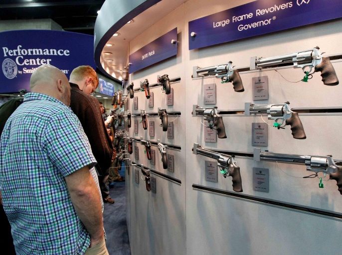 Gun enthusiasts look over Smith & Wesson guns at the National Rifle Association's (NRA) annual meetings and exhibits show in Louisville, Kentucky, May 21, 2016. REUTERS/John Sommers II/File Photo