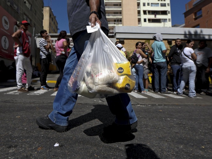 فنزويليون يصطفون أمام مركز تجاري للحصول على مواد غذائية (رويترز)