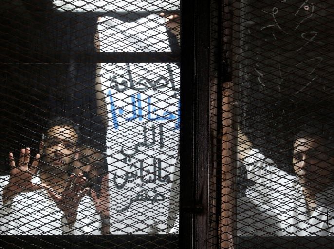 Egyptian journalists gesture behind bars during their trial at a court on the outskirts of Cairo, Egypt May 31, 2016. The banner reads, "Hey Press Syndicate, why is there no support for 10 of us?" REUTERS/Amr Abdallah Dalsh