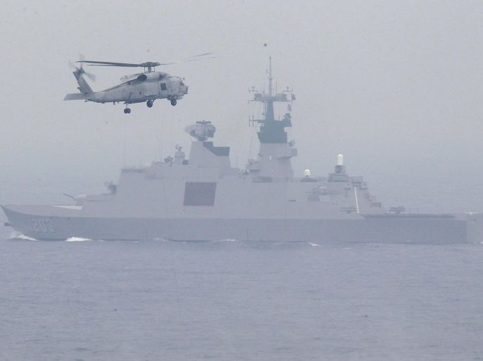 A S-70C helicopter flies past a Lafayette-class frigate during a military drill outside a naval base in Kaohsiung port, southern Taiwan, January 27, 2016. REUTERS/Pichi Chuang