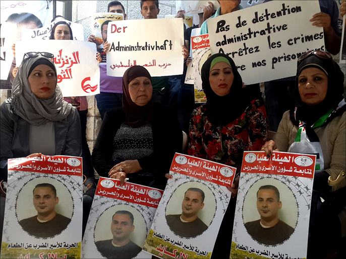 فلسطينيات يحملن صور الأسير بلال كايد بعد مرور 35 يوما على إضرابه المتواصل عن الطعام (الجزيرة)