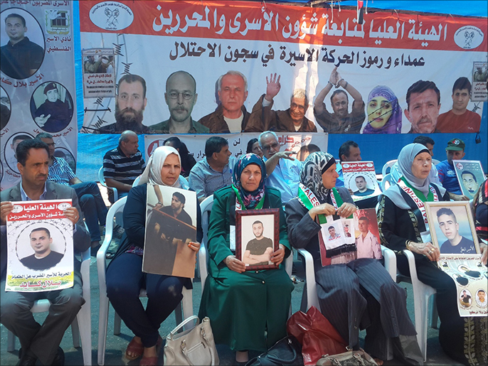 أمهات يحملن صور أبنائهن الأسرى بخيمة للتضامن مع الأسير بلال كايد في رام الله (الجزيرة)