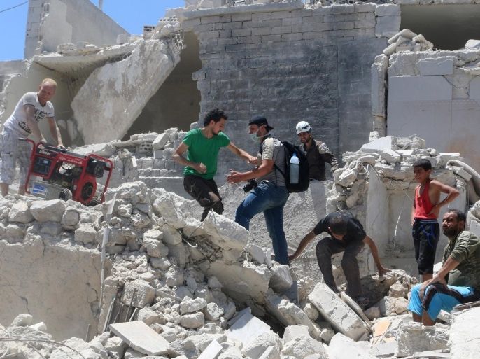People walk on the rubble of a site hit by a barrel bomb in the rebel held area of Old Aleppo, Syria July 11, 2016. REUTERS/Abdalrhman Ismail