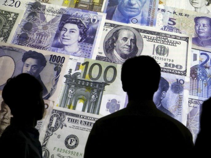 People are silhouetted against a backdrop projected with the picture of various currencies of money in this illustration taken April 4, 2016. REUTERS/Kacper Pempel/Illustration