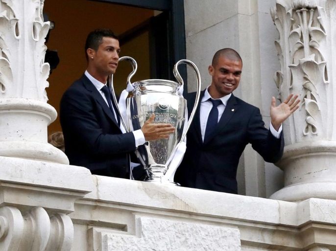 Real Madrid's Cristiano Ronaldo and Pepe hold the Champions League trophy in the balcony of the Madrid Autonomous Government´s headquarter during the celebrations in Madrid, 29 May 2016. Real Madrid won against Atletico Madrid in the UEFA Champions League Final held at Milan's San Siro Stadium on 28 May 2016.