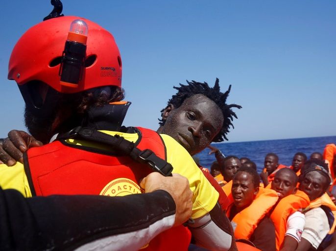 A migrant is carried from an overcrowded dinghy by a member of the Spanish NGO Proactiva during a rescue operation by the Spanish NGO Proactiva, off the Libyan coast in Mediterranean Sea August 28, 2016. REUTERS/Giorgos Moutafis TPX IMAGES OF THE DAY
