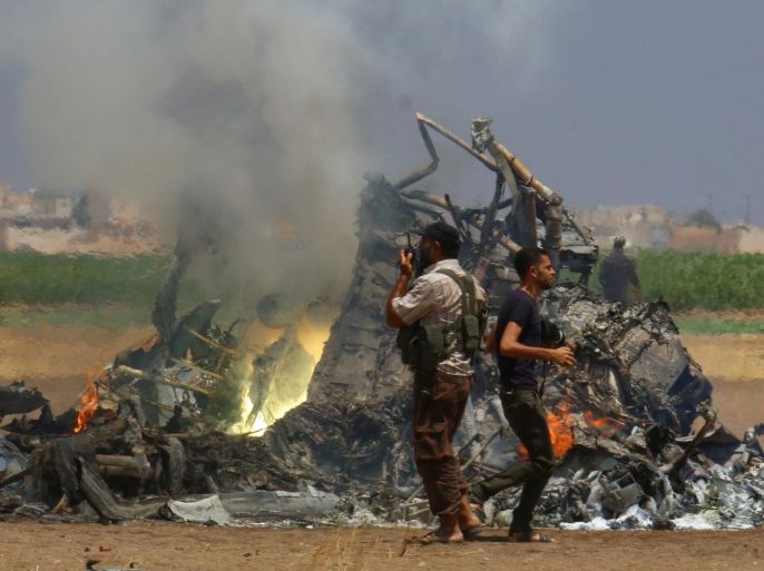 Men inspect the wreckage of a Russian helicopter that had been shot down in the north of Syria's rebel-held Idlib province, Syria August 1, 2016. REUTERS/Ammar Abdullah TPX IMAGES OF THE DAY