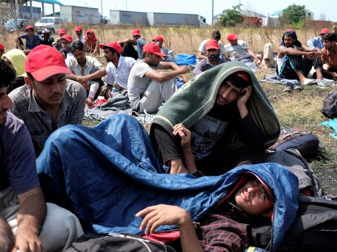 Migrants, mainly from Afghanistan and Pakistan, sit on a field near the Serbian-Hungarian border fence during a hunger strike near the village of Horgos, Serbia July 25, 2016. REUTERS/Marko Djurica