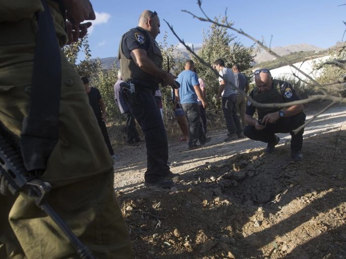 Israeli police and local Druze citizens inspect an apple plantation area hit by a projectile launched from Syria near the Druze village of Majdal Shams, northern Golan Heights, Israel, 13 September 2016. No injuries or damage were reported. An Israeli Army spokesman denied claims by the Syrian government that the Syrian army shot down an Israeli warplane and a drone over the Golan Heights overnight.
