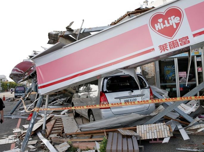 A man stands in front of a damaged vehicle and convenience store after Typhoon Meranti made landfall, in Kaohsiung, Taiwan, September 15, 2016. REUTERS/Tyrone Siu TPX IMAGES OF THE DAY