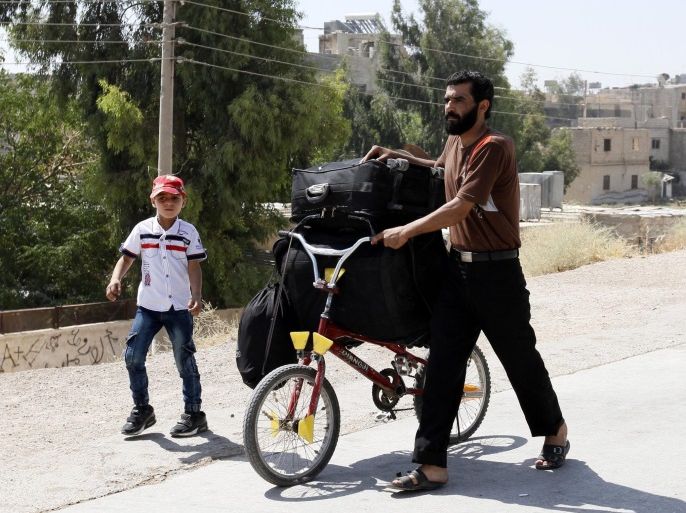 People carry their belongings as they leave the rebel-held area of Mouadamiya, Damascus countryside, Syria, 02 September 2016. According to reports, hundreds were evacuated from Mouadamiya that had been besieged by government forces, under an agreement with Syrian government including civilians and rebel fighters. The evacuees will be relocated to the makeshift center in Harjalleh.