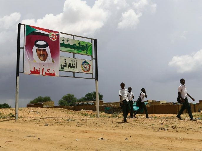People pass a signboard during preparations for the visit of President Omar Al Bashir, Qatari Prince Sheikh Tamim bin Hamad Al Thani and Chad President Idriss Deby toÊsupport the peace process in the war torn Darfur in Al Fashir capital of North Darfur September 5, 2016. REUTERS/Mohamed Nureldin Abdallah