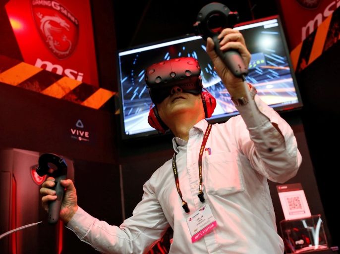 A visitor tries a pair of HTC's Vive Virtual Reality (VR) goggles, during the annual Computex computer exhibition in Taipei, Taiwan June 1, 2016. REUTERS/Tyrone Siu