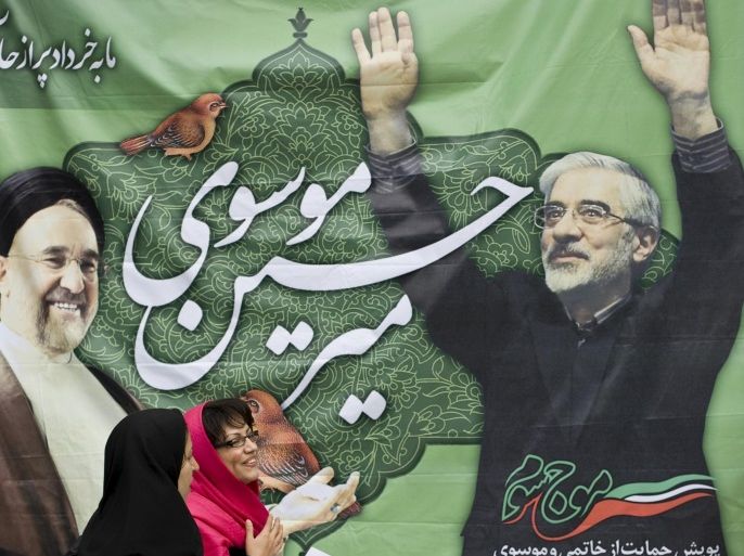Women walk past a picture of then presidential candidate Mir Hossein Mousavi (R) and former President Mohammad Khatami in Tehran in this May 26, 2009 file photo. To match IRAN-ELECTION/OPPOSITION-INSIGHT REUTERS/Raheb Homavandi/Files