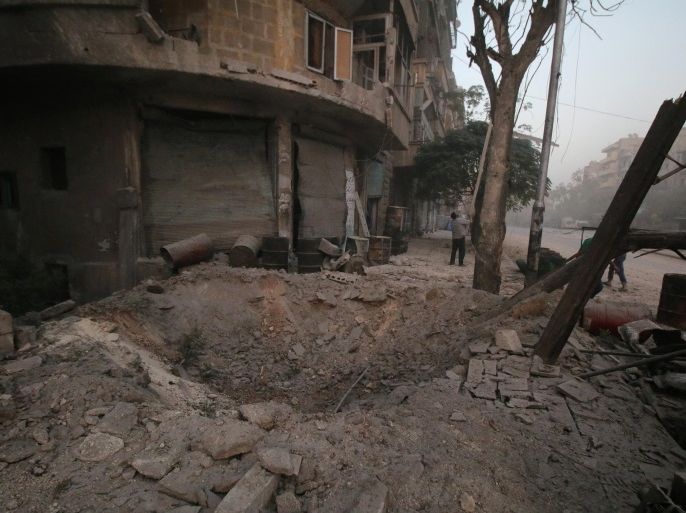 A man inspects damage near a hole in the ground after airstrikes on the rebel held al-Ansari neighbourhood of Aleppo, Syria October 2, 2016. REUTERS/Abdalrhman Ismail