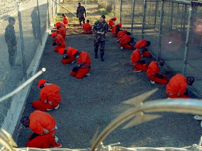 Detainees in orange jumpsuits sit in a holding area while watched by U.S. military police at the temporary Camp X-Ray, which was later closed and replaced by Camp Delta, inside Guantanamo Bay naval base in a January 11, 2002 file photo. President Barack Obama launched a final push on Tuesday to persuade Congress to close the U.S. military prison at Guantanamo Bay, Cuba, but lawmakers, opposed to rehousing detainees in the United States, declared his plan a non-starter. REUTERS/U.S. Department of Defense/Petty Officer 1st Class Shane T. McCoy/Handout/Files via Reuters THIS IMAGE HAS BEEN SUPPLIED BY A THIRD PARTY. IT IS DISTRIBUTED, EXACTLY AS RECEIVED BY REUTERS, AS A SERVICE TO CLIENTS. FOR EDITORIAL USE ONLY. NOT FOR SALE FOR MARKETING OR ADVERTISING CAMPAIGNS TPX IMAGES OF THE DAY