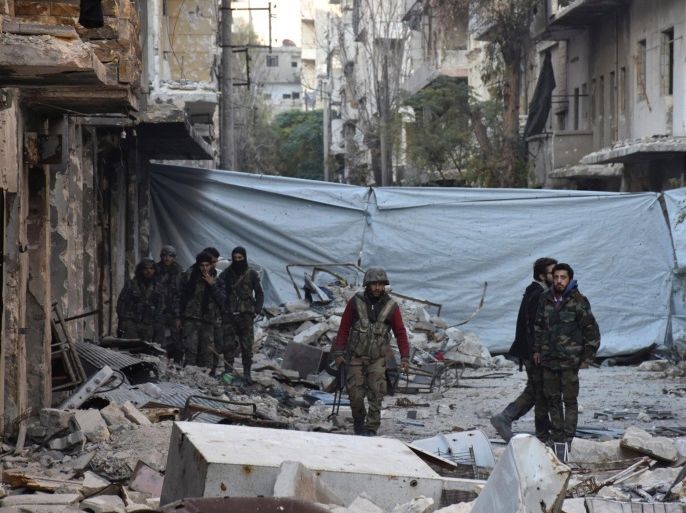 Syrian government soldiers walk amid rubble of damaged buildings, near a cloth used as a cover from snipers, after they took control of al-Sakhour neighborhood in Aleppo, Syria in this handout picture provided by SANA on November 28, 2016. SANA/Handout via REUTERS ATTENTION EDITORS - THIS IMAGE WAS PROVIDED BY A THIRD PARTY. EDITORIAL USE ONLY. REUTERS IS UNABLE TO INDEPENDENTLY VERIFY THIS IMAGE.