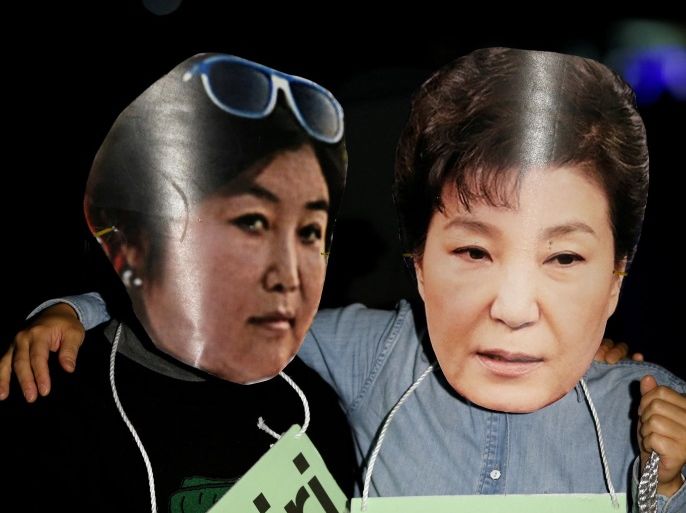 FILE PHOTO: Protesters wearing cut-outs of South Korean President Park Geun-hye (R) and Choi Soon-sil attend a protest denouncing Park over a recent influence-peddling scandal in central Seoul, South Korea, October 27, 2016. REUTERS/Kim Hong-Ji/File photo