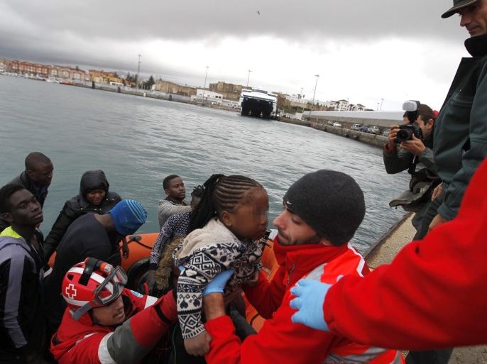 Spanish Red Cross staff members help a Sub-Saharan migrant girl as they arrive in a launch to Tarifa after being rescued off the Strait of Gibraltar, in the province of Cadiz, southern Spain, 22 November 2016. Some 31 Sub-Saharan migrants were intercepted by the maritime rescue forces when trying to reach Spanish territory on board three different small boats. EPA/A. CARRASCO RAGEL ATTENTION EDITORS: FACE OF THE GIRL BLURED DUE TO SPANISH LAW