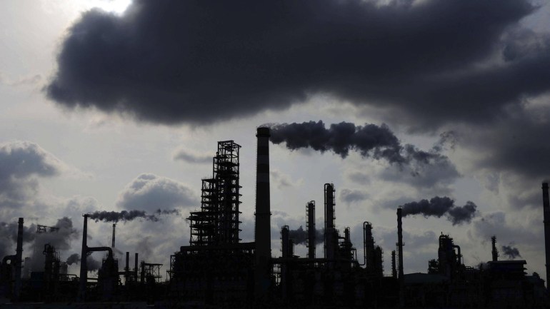 In this photo taken Feb. 9, 2014, clouds loom over Sinopec oil refinery in Qingdao in east China's Shandong province. Growth has marched steadily downward over the past two years as Beijing clamped down on a spending boom that analysts worry has pushed debt to dangerous levels. That has meant less Chinese demand for imported goods from copper and cement to factory machinery and earth movers. (AP Photo) CHINA OUT