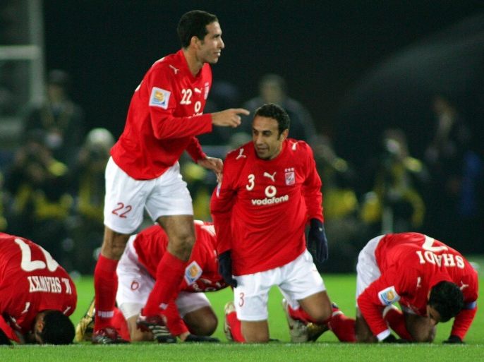 epa00887086 Al Ahli's Mohamed Aboutrika (22) celebrates as his teammates kneel down for direction of the west during the first half of the third place match against Club America in the FIFA Club World Cup Japan 2006 in Yokohama, south of Tokyo, Thursday 17 December 2006. (L-R) Hohamed Shawky (17), Aboutrika, Tarek Said (3) and Shady Mohamed (7). EPA/KIMIMASA MAYAMA