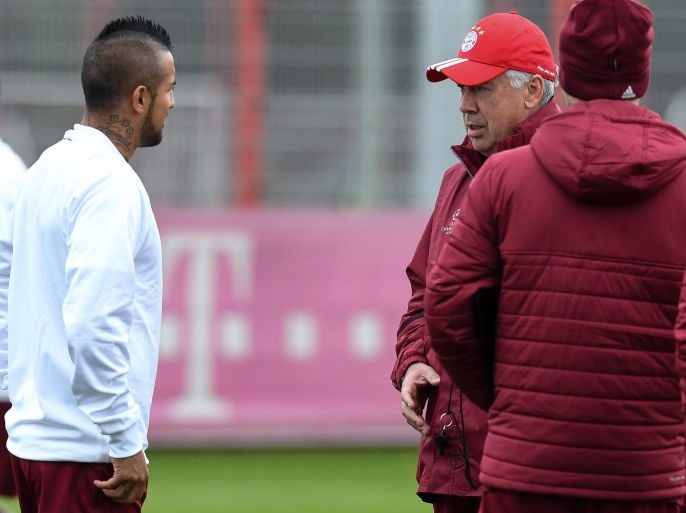 Bayern Munich's Arturo Vidal (L) and head coach Carlo Ancelotti (2-R) speak to each other during a training session of the team in Munich, Germany, 18 October 2016. Bayern Munich will face Dutch team PSV Eindhoven in the group stage of the UEFA Champions League on 19 October 2016.