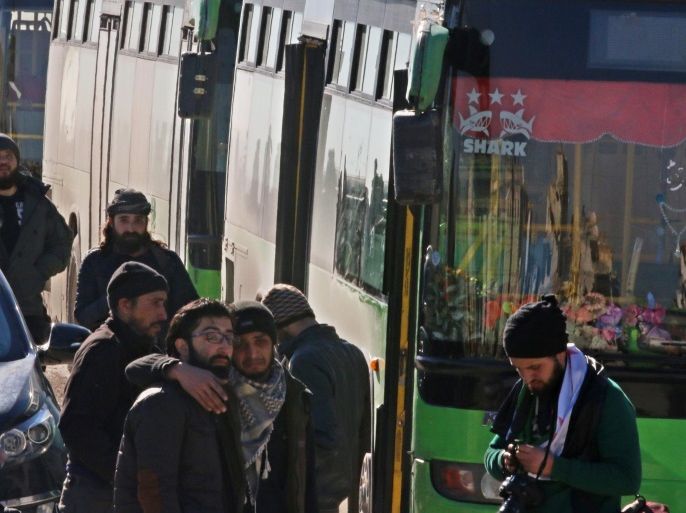 Men react as they stand outside buses evacuating people from a rebel-held sector of eastern Aleppo, Syria December 15, 2016. REUTERS/Abdalrhman Ismail