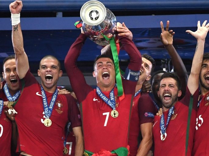 Cristiano Ronaldo (C) of Portugal lifts the trophy after winning the UEFA EURO 2016 Final match against France at Stade de France in Saint-Denis, France, 10 July 2016. (RESTRICTIONS APPLY: For editorial news reporting purposes only. Not used for commercial or marketing purposes without prior written approval of UEFA. Images must appear as still images and must not emulate match action video footage. Photographs published in online publications (whether via the Internet or otherwise) shall have an interval of at least 20 seconds between the posting.)
