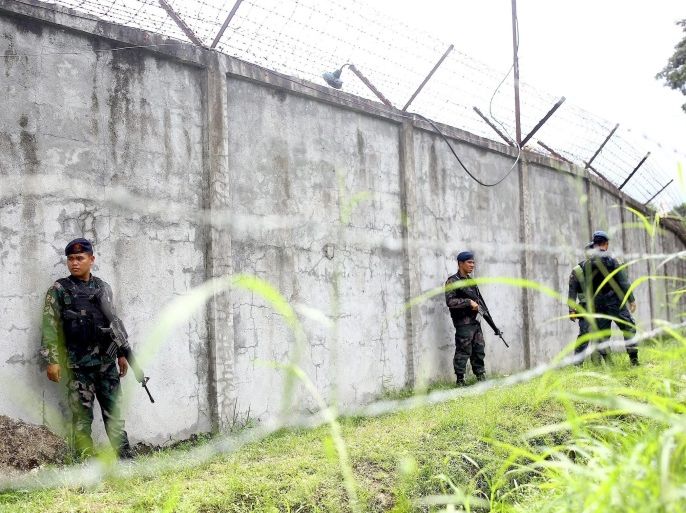 Armed Filipino policemen stand guard next to the wall of a prison facility, where detainees reportedly escaped, in Kidapawan City, North Cotabato province, Philippines, 04 January 2017. According to media reports, more than 100 inmates, including prominent members of a jihadist group, escaped from a prison in the southern Philippines following an armed assault against the compound. The attackers led the assault shortly after midnight in the North Cotabato provincial prison, and engaged in a one-hour gunfight with security guards, leaving one guard dead and one inmate injured. The attack allowed 158 of the nearly 400 inmates housed in the prison to escape, while other local media outlets reported the number to be around 130.