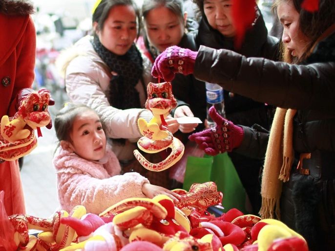 People buy plush toys depicting snakes in Shanghai January 23, 2013. The Lunar New Year, or the Spring Festival, begins on February 10 this year and marks the start of the Year of the Snake. REUTERS/Aly Song (CHINA - Tags: SOCIETY)