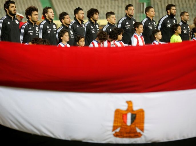 Football Soccer - Egypt v Tunisia - International Friendly Match - Cairo Stadium, Egypt - 8/1/17- Team Egypt listens to the national anthem behind an Egyptian national flag ahead of the match. REUTERS/Amr Abdallah Dalsh
