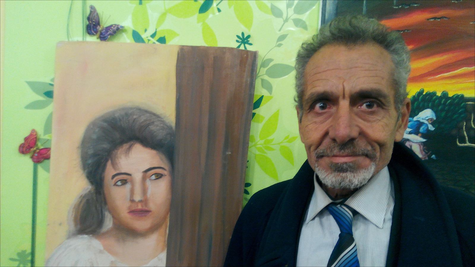 ‪الرسام حسن رسلان أمام إحدى لوحاته في معرض صرخة لون‬ (الجزيرة)