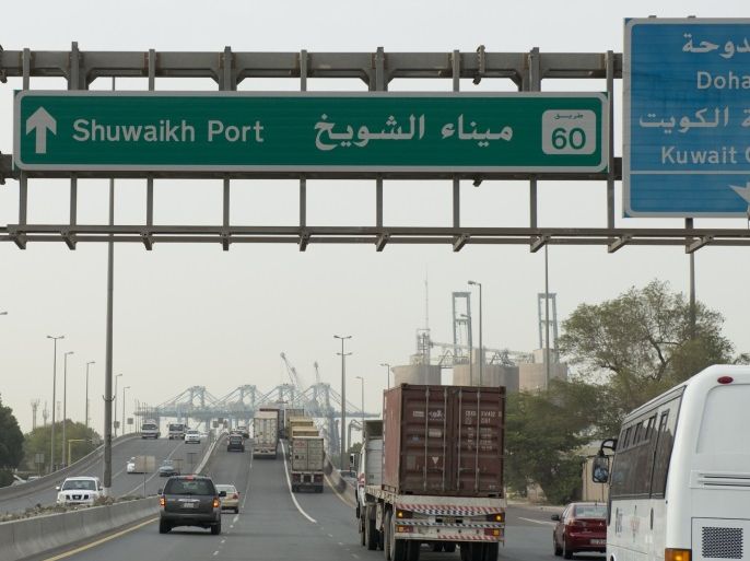 Freight trucks and vehicles drive on the only entrance to Kuwait's Shuwaikh Port from the Ghazalli Bridge in Shuwaikh February 11, 2013. Freight trucks trundle down the dusty, potholed roads of Kuwait's busiest port, running into traffic jams as they emerge into the surrounding streets. But after years of inaction, the government is finally moving to ease the congestion. It is pushing ahead with a $2.6 billion plan to build a 36 km (22 mile) causeway, one of the longe