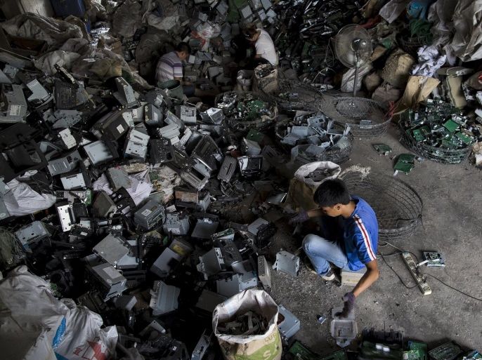 Workers recycle CD players at a workshop in the township of Guiyu in China's southern Guangdong province June 9, 2015. The town of Guiyu in the economic powerhouse of Guangdong province in China has long been known as one of the world’s largest electronic waste dump sites. At its peak, some 5,000 workshops in the village recycle 15,000 tonnes of waste daily including hard drives, mobile phones, computer screens and computers shipped in from across the world. Many of th