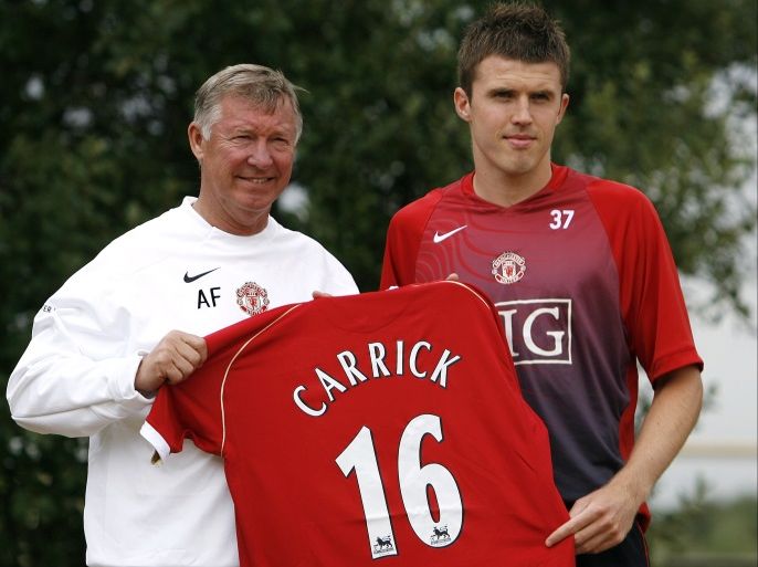Manchester United's new signing Michael Carrick (R) holds his new jersey with manager Alex Ferguson at the Carrington training facility in Manchester, northern England, August 2, 2006. REUTERS/Darren Staples (BRITAIN)