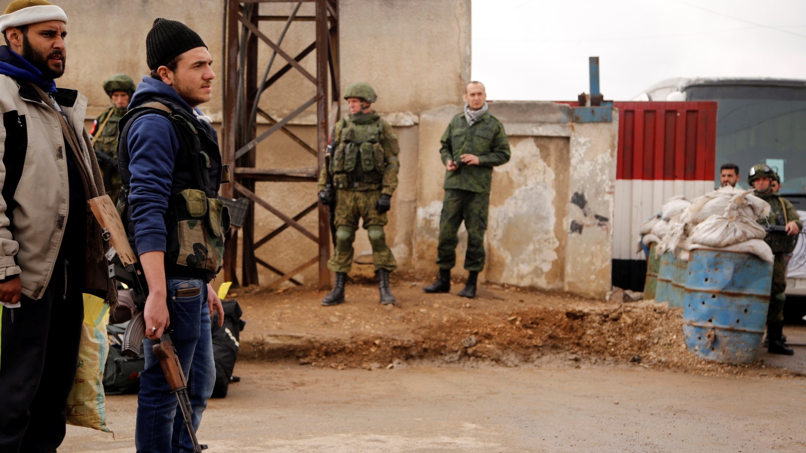 ‪جنود روس راقبوا خروج الدفعة الأولى من المدنيين ومقاتلي المعارضة من حي الوعر‬ (رويترز)