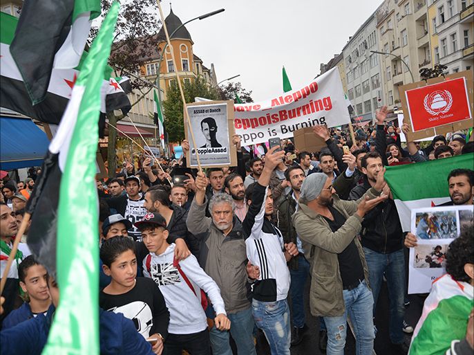 لاجئون سوريون يرفعون بمظاهرة في برلين لافتات تطالب بجلب الأسد لمحكمة الجنايات الدولية. الجزيرة نت