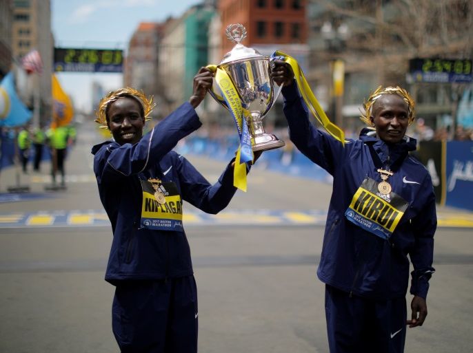 Women's division winner Edna Kiplagat (L) and men's division winner Geoffrey Kirui, both of Kenya, pose with the trophy at the finish line of the 121st Boston Marathon in Boston, Massachusetts, U.S., April 17, 2017. REUTERS/Brian Snyder