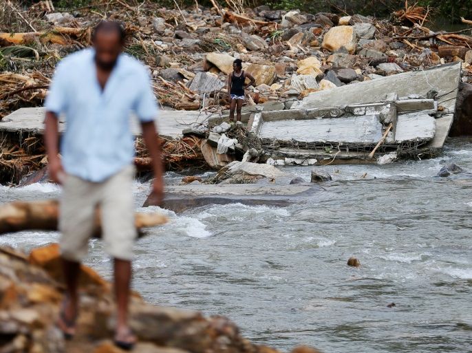 A man stands on top of the debris of a house at a landslide site during a rescue mission in Athwelthota village, in Kalutara, Sri Lanka May 28, 2017. REUTERS/Dinuka Liyanawatte