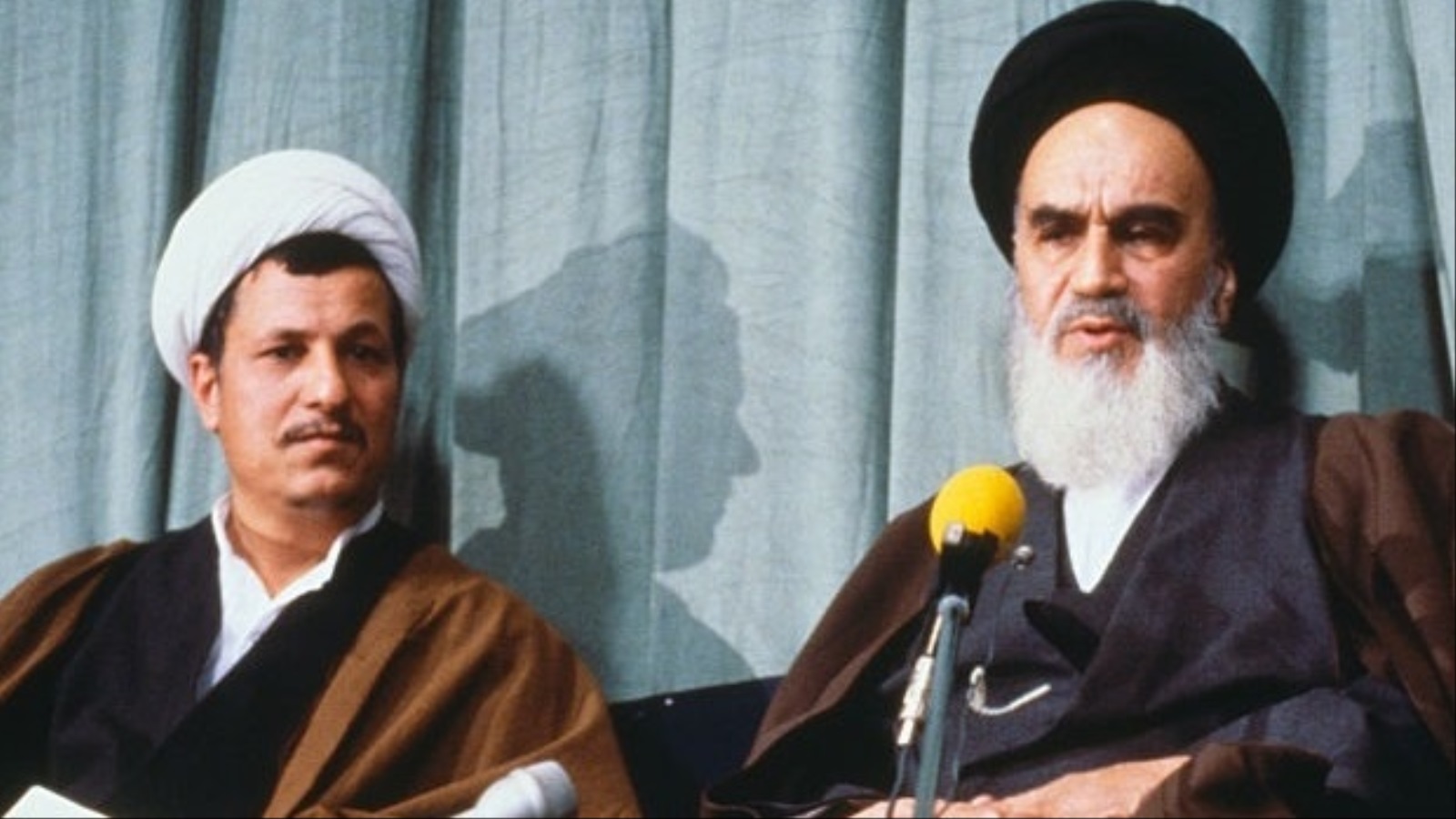 علي أكبر هاشمي رفسنجاني إلى جاني الخميني، شغل العديد من المناصب منها رئاسة البرلمان والجموهورية لدورتين (1934-2017) (رويترز)