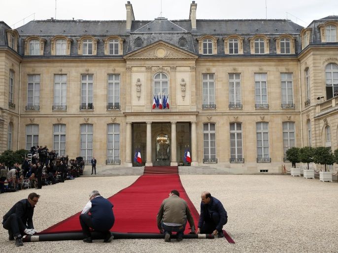 PARIS, FRANCE - MAY 14: Employees set up the red carpet on the steps of the Elysee Presidential Palace in final preparations for the handover ceremony between France's newly-elected President Emmanuel Macron and outgoing President Francois Hollande on May 14, 2017 in Paris, France. Macron was elected President of the French Republic on May 07, 2017 with 66,1 % of the votes cast. (Photo by Thierry Chesnot/Getty Images)