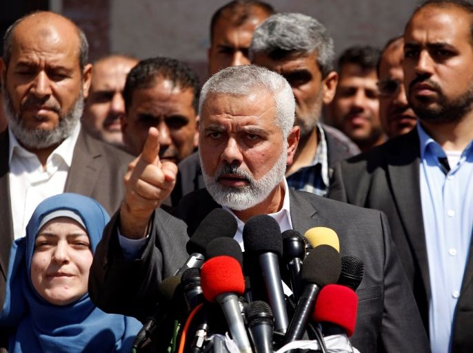Hamas Chief Ismail Haniyeh gestures during a news conference as the wife of slain senior Hamas militant Mazen Fuqaha stands next to him, in Gaza City May 11, 2017. REUTERS/Mohammed Salem