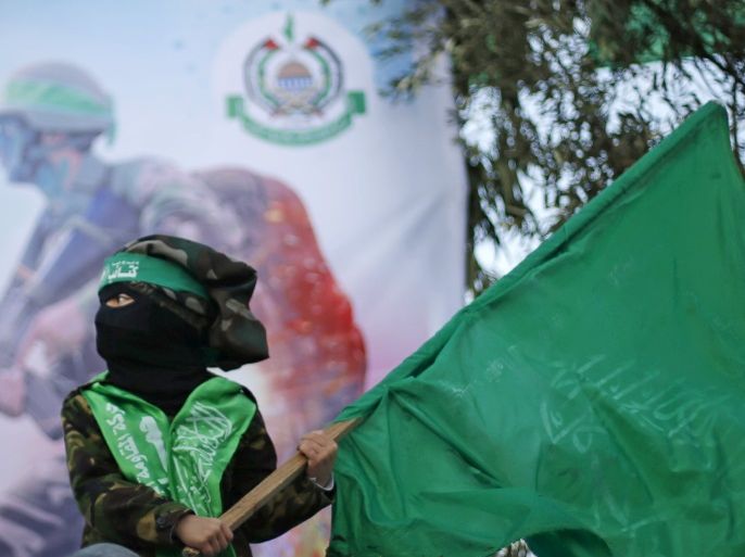 A masked Palestinian boy wearing a military fatigue waves a Hamas flag during a rally in support of what organizers said is a Palestinian uprising against Israel, in Beit Lahiya town in the northern Gaza Strip January 22, 2016. REUTERS/Suhaib Salem