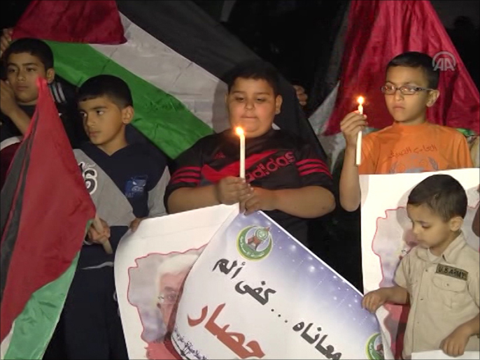 أطفال يتظاهرون بالشموع احتجاجا على أزمة الكهرباء بغزة(وكالة الأناضول)